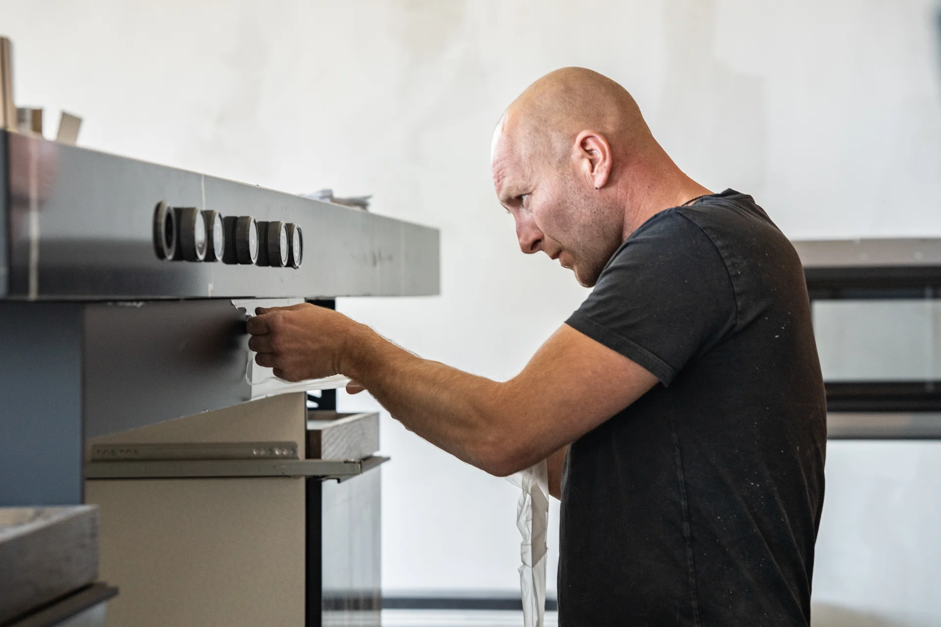 Monteur bouwt een kookplaat in de keuken in