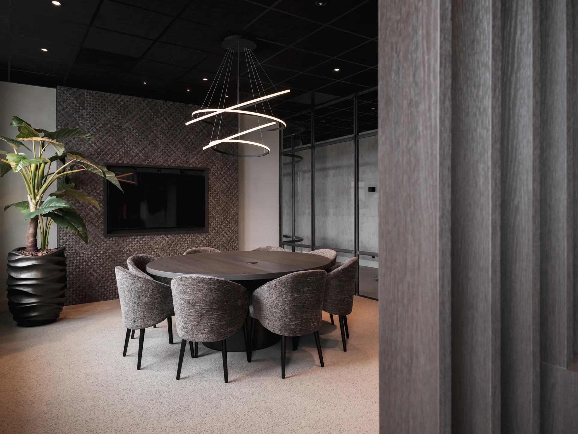Afgewerkt interieur met ronde vergadertafel en maatwerk lattenwand